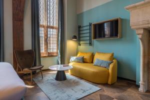 米德尔堡Hotel St Joris I Kloeg Collection的客厅设有黄色沙发和电视
