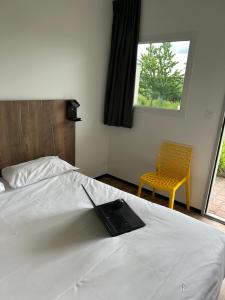 图勒The Originals Access, Hôtel Tulle (P'tit Dej-Hotel)的一间卧室配有一张带笔记本电脑的床