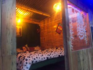 卡索尔Shanti People Huts & Camp的躺在木板房床里的人