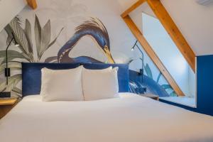 米德尔堡Hotel St Joris I Kloeg Collection的卧室配有一张特大号床,墙上有一只鸟