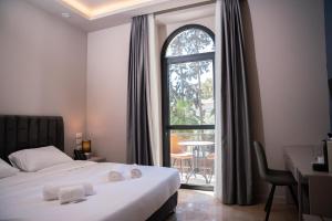 耶路撒冷All Seasons Boutique Hotel - Jerusalem的酒店客房设有一张床和一个大窗户