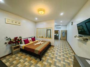 董里Trang Villa Hotel and Water Park的一间卧室配有一张床和一台电视。