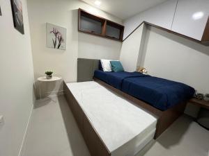 梅尔皮姆Hi Sea E272 At Escape Condominium Mae Pim Beach的小卧室配有一张带蓝色毯子的床