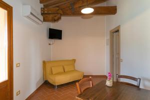 皮昂比诺Isolotto - Appartamento Quercia的客厅配有桌子和黄椅