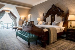 多尼戈尔哈维波恩特酒店的一间大卧室,配有一张大床和一张绿色长凳