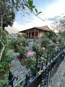 ChaïdeftónValsamo Luxury Cottage的围栏前有粉红色花的房屋