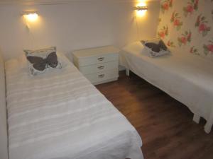 KumlaHuldas Gård的小客房内的两张床,配有白色床单