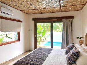 圣维森特Yumi Villas的一间卧室配有一张床,享有游泳池的景色