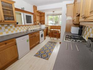 滕比Little Rosemount的厨房配有木制橱柜和炉灶烤箱。