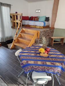 圣佩德罗·德·阿塔卡马Cabañas Rica-Rica Lodge的一间设有桌子和一张桌子的床铺的房间