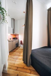 里加Constantine Apartments的一间卧室配有一张床,铺有木地板