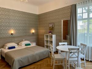 派尔努格林别墅酒店的卧室配有一张床和一张桌子及椅子