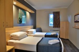 约翰内斯堡Road Lodge Rivonia的酒店客房设有两张床和窗户。