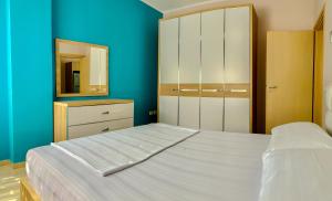 奥里库姆Endy Apartaments的卧室配有白色的床和镜子