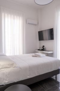 雷焦卡拉布里亚Domea Superior Rooms Bed and Breakfast的一间白色卧室,配有床和电视