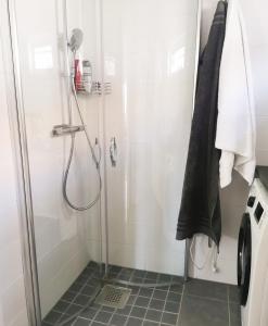 瓦克斯霍尔姆Holiday home on Resaro only 400 m from the sea的带淋浴和黑色毛巾的浴室