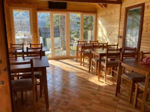 瓦勒博内Bujtina Arturi的用餐室设有桌椅和窗户。