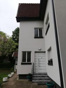 弗尔尼亚奇卡矿泉镇Kuća JEKA的白色的房子,有门和楼梯