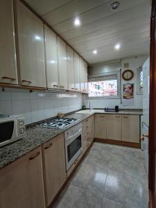 萨瓦德尔LG DownTown Sabadell Apartment的厨房配有白色橱柜和炉灶烤箱。