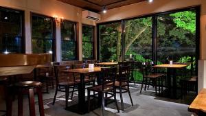 日光Shinkyo Inn的餐厅设有桌椅和大窗户。