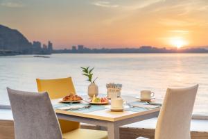 阿利坎特阿利坎特美利亚酒店的日落时在海滩上用餐的餐桌