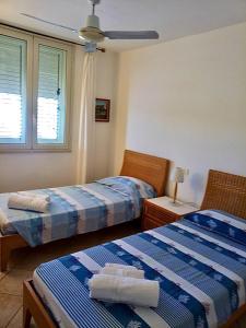兰佩杜萨Attico sul Porto Vecchio - Lampedusa的一间卧室设有两张床和窗户。