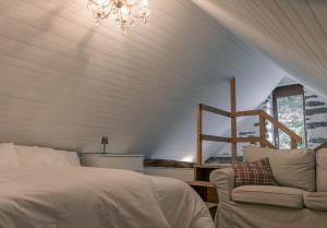 FrascoVerzasca Lodge Carlotta的一间卧室配有一张床、一张沙发和一个吊灯。
