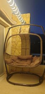 艾因苏赫纳Chalet in Blumar El Dome for families only的坐在房间里的一个柳条摇椅