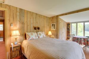 索尔兹伯里Serene Salisbury Rental Home on 26 Acres with Deck!的卧室配有一张床铺,位于带木墙的房间内