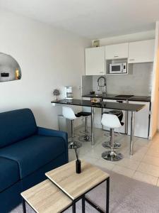 戛纳Appartement 2 pièces de 29 m2的一间带蓝色沙发的客厅和一间厨房