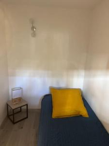 戛纳Appartement 2 pièces de 29 m2的一张带黄色枕头和边桌的床