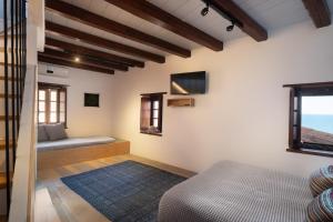 莫奈姆瓦夏Kalnterimi Guesthouses的卧室配有一张床,墙上配有电视。