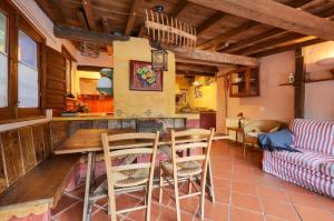 圣胡安-德拉斯阿巴德萨斯Galliner, El Reixac Casa Rural的厨房以及带桌椅的起居室。
