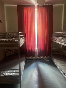 索非亚Bla Bla Hostel的客房设有两张双层床和一扇带红色窗帘的窗户。