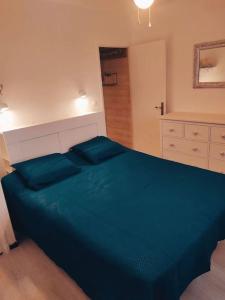 韦尔东的圣克鲁瓦Maison de village type 2的一间卧室,卧室内配有一张蓝色大床