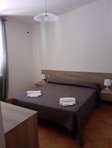斯卡莱阿Parco Meridiana的一间卧室配有带毛巾的床