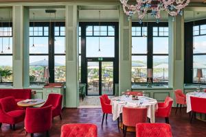 卢塞恩古奇城堡酒店的餐厅设有红色的椅子和桌子以及窗户。