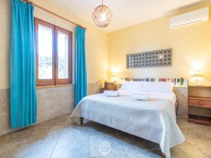 普佐伊杜Casa Ida - Wonderful Vacation的一间卧室配有一张带蓝色窗帘的床和一扇窗户