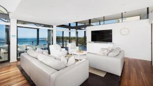 安娜湾Sails on the Beachfront - Exclusive Seaside Home的客厅配有白色家具和玻璃窗。