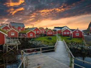 雷讷Reine Rorbuer - by Classic Norway Hotels的水面上一群红色的房子,有码头