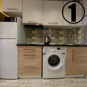 哈尔科夫Studio Aparment的厨房配有洗衣机和冰箱。