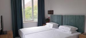 AreniAreni Lodge的一间卧室设有两张白色的床和窗户