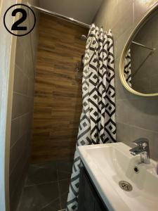 哈尔科夫Studio Aparment的浴室配有盥洗盆和带镜子的淋浴