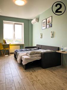哈尔科夫Studio Aparment的一间卧室配有一张床、一张桌子和一个窗户。