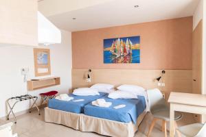 科斯镇阿奇里斯公寓式酒店的一间卧室配有蓝色的床和桌椅