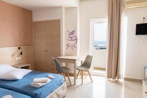 科斯镇阿奇里斯公寓式酒店的酒店客房带一张床、一张桌子和椅子