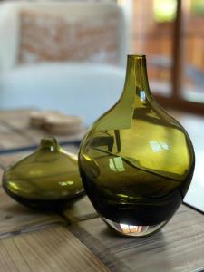 奥伯劳Das Bergquartier - Ferienwohnung Rabenkopf的木桌边的两只绿色玻璃花瓶