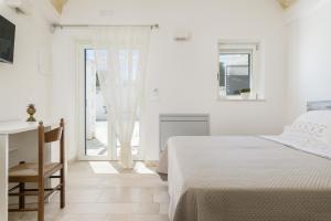 奥斯图尼Masseria Abadia Uno的白色卧室配有床和书桌