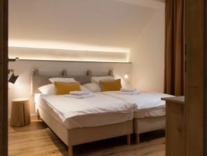 让贝克Hegyalja Étterem és Panzió的卧室配有一张带黄色枕头的大型白色床。