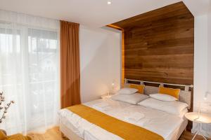 让贝克Hegyalja Étterem és Panzió的一间卧室配有一张大床和木制床头板